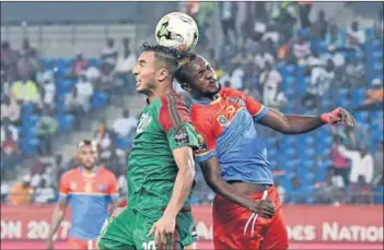  ??  ?? Afcon colour and commitment: Fans at the Burkina Faso vs Cameroon match (left) and Democratic Republic of the Congo midfielder Merveille Bokadi (right) and Morocco’s Aziz Bouhaddouz clash during the group C football match on Monday.