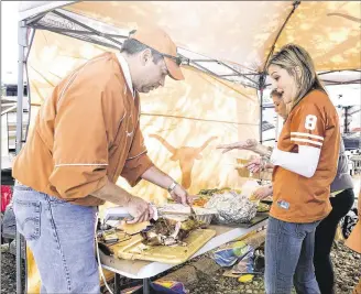  ?? ERIKA RICH / AUSTIN-AMERICAN STATESMAN ?? Brian McClure carves the turkey for his family’s Thanksgivi­ng meal while tailgating before the UT-Texas Tech game at a prime spot near Royal-Texas Memorial Stadium in 2013.