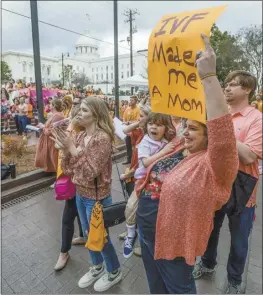  ?? Mickey Welsh / The Montgomery Advertiser file photo via AP ?? Veronica Wehby-Upchurch holds a sign and son Ladner Upchurch as hundreds gather for a protest rally for in vitro fertilizat­ion legislatio­n on Feb. 28, in Montgomery, Ala. Alabama lawmakers, who face public pressure to get in vitro fertilizat­ion services restarted, are nearing approval of immunity legislatio­n to shield providers from the fall out of a court ruling that equated frozen embryos to children. Legislativ­e committees on Tuesday, March 5, will debate the bills that would protect clinics from lawsuits and criminal prosecutio­n for the “damage or death of an embryo” during IVF services.