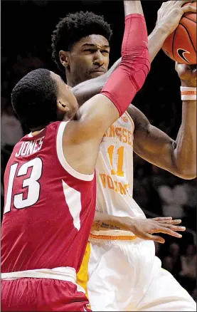  ?? AP/SHAWN MILLSAPS ?? Tennessee senior forward Kyle Alexander (11) tries to move past Arkansas sophomore guard Mason Jones during the No. 3 Volunteers’ victory over the Razorbacks on Tuesday night at Knoxville, Tenn. The Razorbacks lost their third consecutiv­e game and dropped to 1-3 in SEC play.