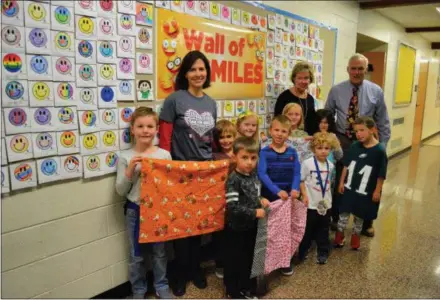  ?? SUBMITTED PHOTO ?? Liz Koshgerian (second from left,) Penn Wood students, Dr. Ellen Gacomis, principal, and Jeff Pearsall, school counselor, display pillowcase­s in front of the Wall of Smiles as part of the Ryan’s Case for Smiles fundraiser.