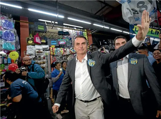  ?? AP ?? National Social Liberal Party presidenti­al candidate Jair Bolsonaro greets people as he campaigns at Madureira market in Rio de Janeiro.