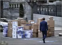  ?? GERALD HERBERT – THE ASSOCIATED PRESS ?? A man walks past boxes that were moved out of the Eisenhower Executive Office building, just outside the West Wing, inside the White House complex, on Jan. 14, 2021, in Washington.