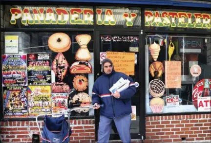  ?? THE ASSOCIATED PRESS ?? A mail carrier passes a closed bakery Thursday, Feb. 16, 2017, in south Philadelph­ia’s Italian Market. In an action called “A Day Without Immigrants”, immigrants across the country are expected to stay home from school and work on Thursday to show how...