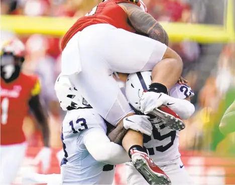  ?? JULIO CORTEZ /AP ?? Maryland running back Challen Faamatau, top, tries to hurdle over Penn State linebacker Ellis Brooks (13) and cornerback Daequan Hardy last Saturday, in College Park, Md.