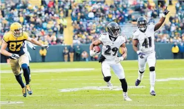  ?? STACY REVERE/GETTY IMAGES ?? Ravens rookie cornerback Marlon Humphrey gains yardage after intercepti­ng a pass against the Packers during the second half Sunday. Humphrey, the team’s top draft pick, is pushing veterans for more playing time.