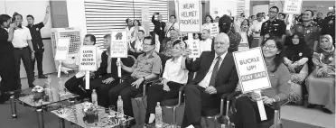  ??  ?? (Seated from left) Abdul Aziz, Ting, Lee, Cheng, Mienczakow­ski and Davina hold placards in support of #ShellSelam­atSampai programme during the launching ceremony.