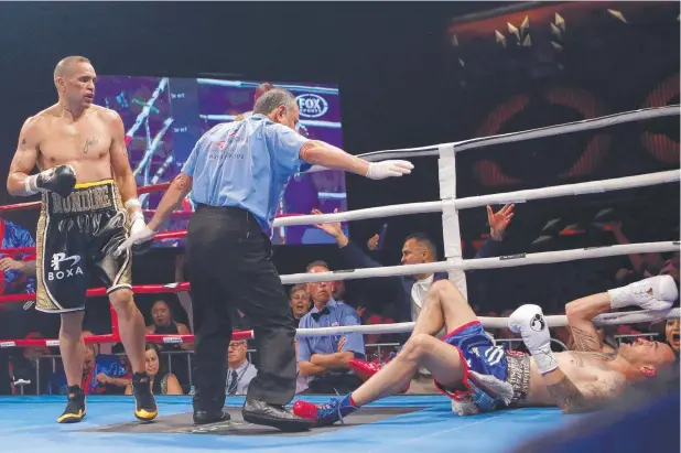  ?? Picture: AAP IMAGE/DANIEL MUNOZ ?? DOWN AND OUT: Anthony Mundine fells Tommy Browne with a vicious left hook.