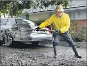  ??  ?? MARK VANCE shovels excess mud outside his Montecito home that was left over from the Jan. 9 storm that swept away homes and killed 21 people.