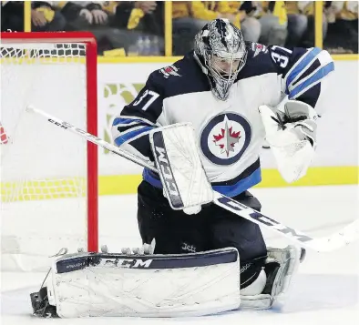  ?? MARK HUMPHREY / THE CANADIAN PRESS ?? Winnipeg goalie Connor Hellebuyck makes a stop during last season’s playoffs. The Jets goalie, like all NHL netminders, will be sporting a smaller chest protector this season as the league moves forward on a stated initiative.