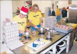  ??                            ?? Kingston Lions Len Gregory and Rick Acker, the designated egg crackers, keep things moving at the annual Christmas Eve breakfast held by the club.