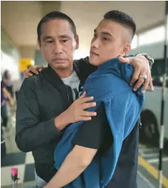  ??  ?? Nur Muhammad Arif and his father hug each other upon his arrival from Kuching.