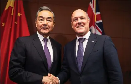  ?? Photograph: Getty Images ?? Chinese foreign minister Wang Yi greets New Zealand prime minister Christophe­r Luxon in Wellington on 18 March 18. New Zealand has opted against applying sanctions over China’s alleged hacking operations.