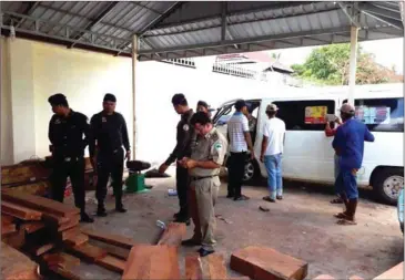  ?? SUPPLIED ?? Officials inspect timber found in a raid that recovered hundreds of luxury ing to a man nicknamed ‘Oknha Thai’ in Stung Treng province yesterday. logs at a residence belong-