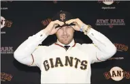  ?? MARCIO JOSE SANCHEZ — ASSOCIATED PRESS ?? New Giants third baseman Evan Longoria, a three-time All-Star in Tampa Bay, shows off his cap and uniform during a press event announcing his arrival Friday at AT&amp;T Park.