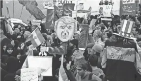  ?? EPA-EFE ?? Iranians hold a caricature of President Donald Trump during an anti-U.S. rally marking the 39th anniversar­y of the U.S. Embassy takeover in 1979.