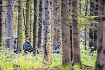  ?? FOTO: SEBASTIAN GOLLNOW/DPA ?? Polizeibea­mte in einem Waldstück bei Villingend­orf.