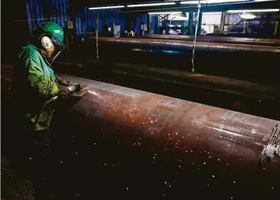  ?? Michael Ciaglo / Houston Chronicle file ?? JSW Steel’s Juan Silva smooths out a section of pipe in Baytown. The energy industry relies heavily on foreign steel.