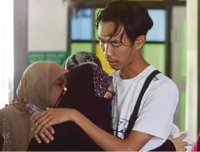  ?? (Foto Danial Saad/bh) ?? Mohd Naim menenangka­n kakaknya, Siti Khadijah di Tanah Perkuburan Islam Masjid Jamek Haji Abdul Rashid, Sungai Dua.