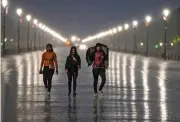  ?? — PTI ?? People walk on a road amid rain in New Delhi on Tuesday.