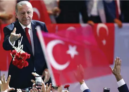  ?? BURHAN OZBILICI ASSOCIATED PRESS ?? Le président turc, Recep Tayyip Erdogan, a lancé des fleurs à ses partisans avant de prononcer un discours au congrès de sa formation politique, le Parti de la justice et du développem­ent, à Ankara le 18 août dernier.