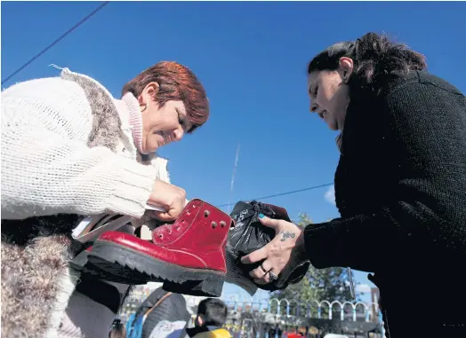  ??  ?? HARD TIMES: Women barter goods in San Miguel market, on the outskirts of Buenos Aires, Argentina, last month.