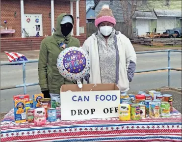  ?? Contribute­d ?? Whitney McCombs (left) and Sandra Glass Smith watch over the canned food drive table at the 19th Annual MLK, Jr. “Youth” Infusion and Community Service Rally in Cedartown on Saturday, Jan. 15.
