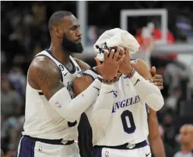  ?? — reuters ?? Injured: Los angeles Lakers’ Lebron James (left) holds a towel to the head of teammate russell Westbrook who was bleeding after clashing with San antonio Spurs’ Zach Collins.