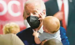  ?? EVAN VUCCI/AP ?? President Joe Biden holds a baby as he visits a COVID-19 vaccinatio­n clinic Tuesday in Washington. U.S. children under 5 are now eligible to receive the vaccine.