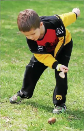  ?? KRISTI GARABRANDT — THE NEWS-HERALD ?? Even though everyone else had finished, Colin Woulff, 4, of Mentor, was determined to roll his egg across the finish line using a wooden spoon at the James A. Garfield Historic Site Easter Monday Egg Roll.