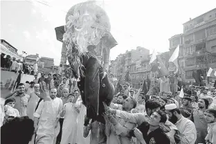  ?? AP Photo/Muhammad Sajjad ?? n Pakistani protesters burn an effigy of President Donald Trump on Thursday in Peshawar, Pakistan. Protesters objected to Trump’s allegation that Islamabad is harboring militants who battle U.S. forces in Afghanista­n.