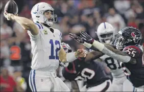  ?? Tim Warner / Getty Images ?? Andrew Luck of the Colts throws a pass under pressure from the Texans’ Benardrick Mckinney Saturday. Luck threw for 222 yards and two scores.