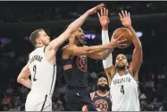  ?? Julie Jacobson / Associated Press ?? Knicks guard Courtney Lee puts up a shot Nets guard Nik Stauskas, left, and center Jahlil Okafor during Tuesday’s game in New York.