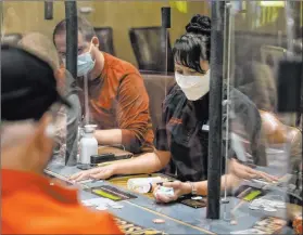  ?? Elizabeth Brumley Las Vegas Review-journal ?? Poker dealer Melissa Moses deals an eighthande­d game protected by plexiglass dividers, at the Red Rock
Resort poker room on Monday.