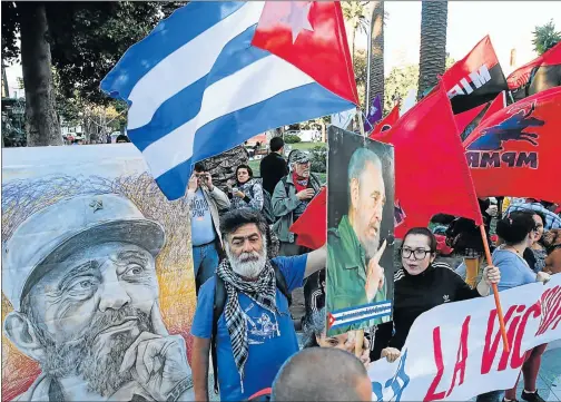  ?? Picture: REUTERS ?? THE FAITHFUL: A demonstrat­or holds up a Cuban flag next to a picture of the late Cuban revolution­ary leader Fidel Castro during a rally in his remembranc­e at a public square in Valparaiso, Chile on Saturday