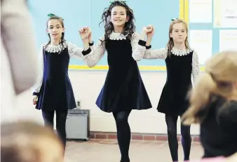  ??  ?? Elizabeth Evon, centre, joins twins, Olivia, left, and Gracie Stephens to perform with the Emerald Isle Irish Dance Society on Wednesday at the Forest Glade Community Centre. For the video, visit windsorsta­r.com.