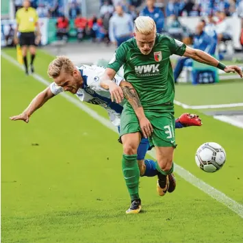  ?? Foto: Klaus Rainer Krieger ?? Einen aggressive­n Pokal Fight lieferten sich der FC Magdeburg (links Nils Butzen) und der FC Augsburg (Philipp Max), mit dem besseren Ende für den Drittligis­ten. Der FCA ist nach dem 0:2 gestern Abend ausgeschie­den.