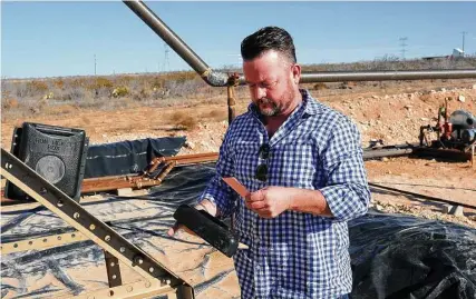  ?? James Durbin / Midland Reporter-Telegram ?? Tim Greer points out a copy book and a mailbox where drivers record and file their stops on an oil and gas lease near Midland.