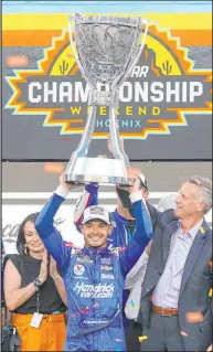  ?? Rick Scuteri The Associated Press ?? Kyle Larson holds up the trophy after winning his first NASCAR Cup Series championsh­ip on Sunday at Phoenix Raceway.