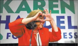  ?? Curtis Compton ?? Atlanta Journal-constituti­on Republican Karen Handel makes a heart symbol in an early appearance to thank her supporters after the first returns came in Tuesday during her election night party.