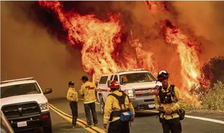  ?? — AP ?? Blazing heat: Firefighte­rs monitoring flames from the LNU Lightning Complex fire at Butts Canyon Road in Lake County, California.