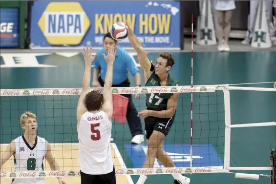  ?? UNIVERSITY OF HAWAI‘I ATHLETICS photo ?? University of Hawaii outside hitter Colton Cowell hits against Harvard’s Griffin Schmit as Rainbow Warriors libero Gage Worsley looks on during UH’s win in the Raising Cane’s Rainbow Warrior Classic on Jan. 10, 2020. Cowell’s UH career has been a long, winding road, starting as a little-used serving specialist before developing into an All-American outside hitter for the No. 1 team in the country.