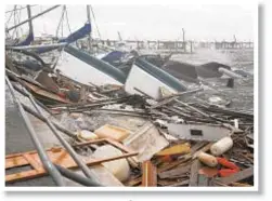  ??  ?? Boats blown by Hurrican Michael form pile of debris in Panama City, Fla. Below, people check car after hotel canopy crashed down on it.