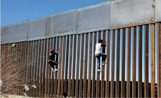  ?? BILD: SN/APA/AFP/H. MARTINEZ ?? Ein besseres Leben suchen arme Latinos vielfach in den Vereinigte­n Staaten: Migranten versuchen, die schon bestehende­n Barrieren an der Grenze Mexikos zu den USA zu überwinden. Präsident Trump will zusätzlich eine Mauer bauen.