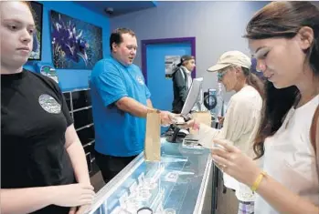  ?? David Royal For The Times ?? GRANT PALMER, center left, owner of a Santa Cruz pot dispensary, voiced his concerns about taxes to Lt. Gov. Gavin Newsom at a March fundraiser. His business gave $5,000 to Newsom’s gubernator­ial bid.