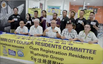  ??  ?? Yii (seated, centre) joins councillor­s and RC members in a photo-call after the announceme­nt of MCC’s plan to set up more WhatsApp chat groups for the RCs.