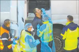  ?? Aaron Chown The Associated Press ?? A man undergoes a COVID-19 test Thursday at the Port of Dover in Kent, England, where thousands wait to resume their journey across the English Channel.