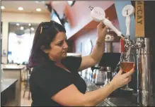  ??  ?? Manager Jennifer Silveira pours a pink rose, donated by Oakridge Winery, at Porter’s Pub in Downtown Lodi on Thursday. Porter’s Pub is holding a breast cancer awareness fundraiser on Saturday.