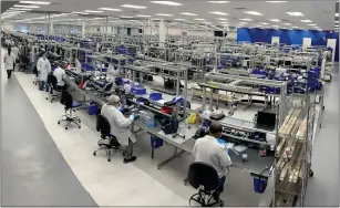  ?? COURTESY OF OLYMPUS CORP. ?? Olympus employees sit at and walk near work areas in the company's repair center in south San Jose. The new location totals 130,000 square feet.