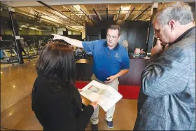  ?? NWA Democrat-Gazette/J.T. WAMPLER ?? Springdale parks and recreation director Bill Mock (center) talks with City Council member Amelia Taldo-Williams and Mayor Doug Sprouse on Monday at the former All-Star Sports Arena, now called Next Level in Springdale. The city recently bought the building, and it will become the new recreation center but it needs renovation­s.